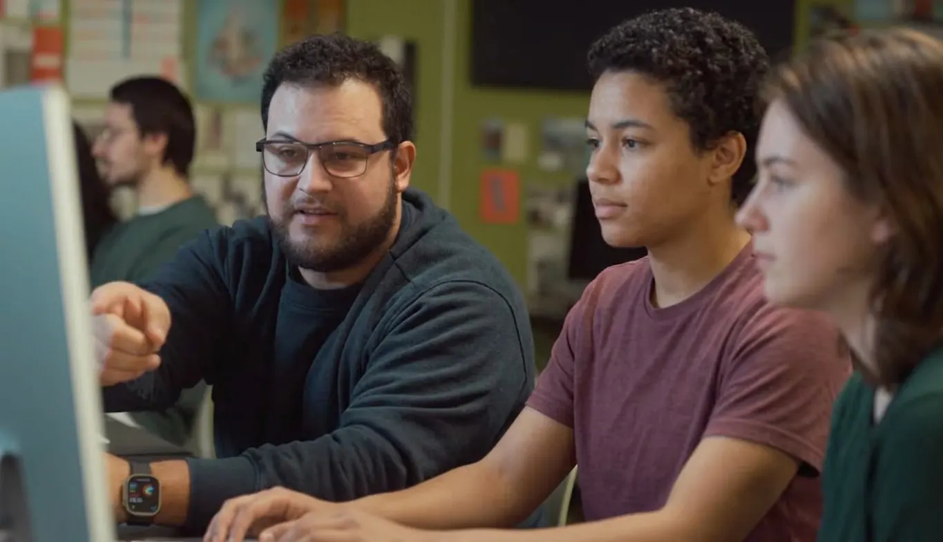 Sebastian Giraldo working with students at a computer